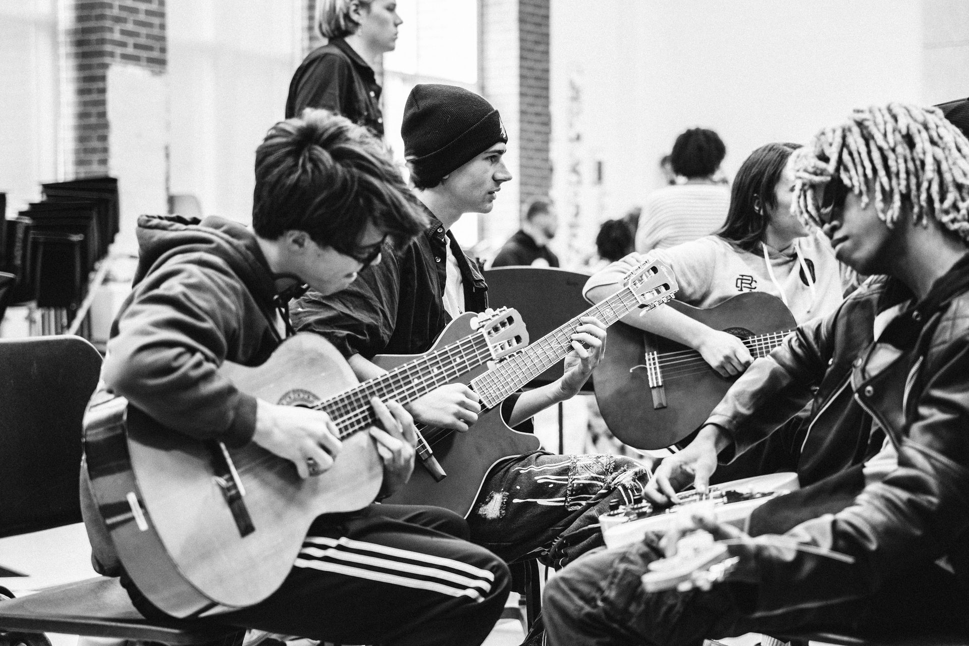 Students playing guitars in a classroom session