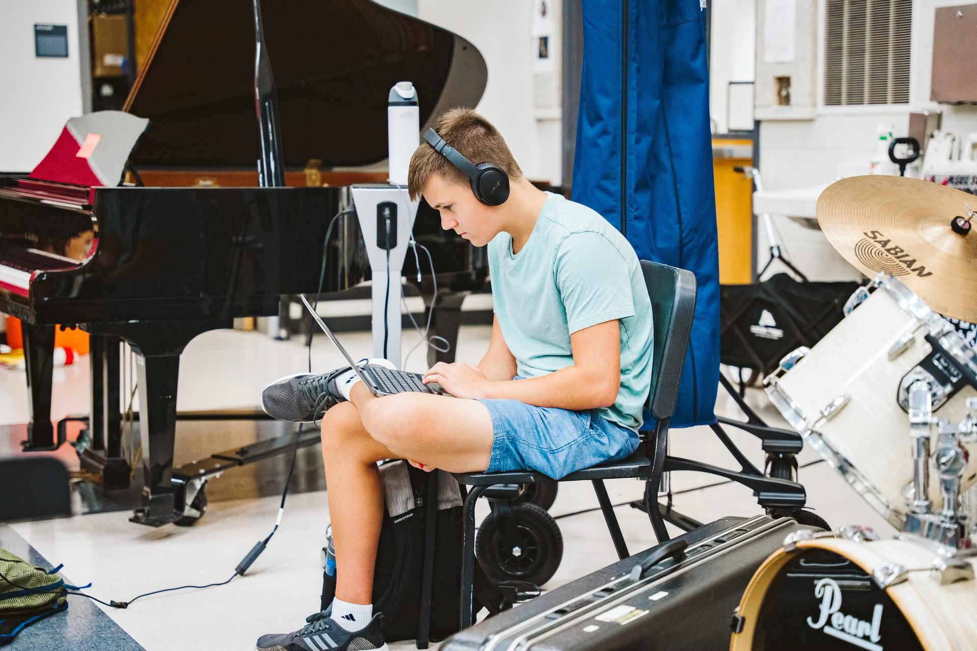 A student producing on a laptop in the band room